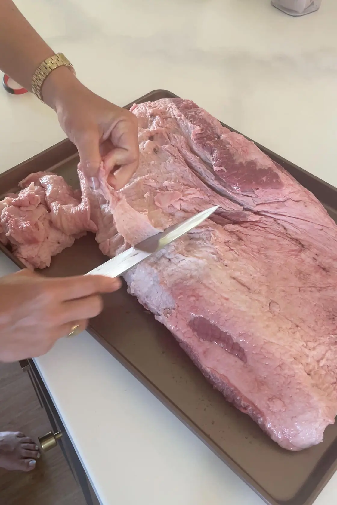 Trimming the fat off of the brisket before smoking.